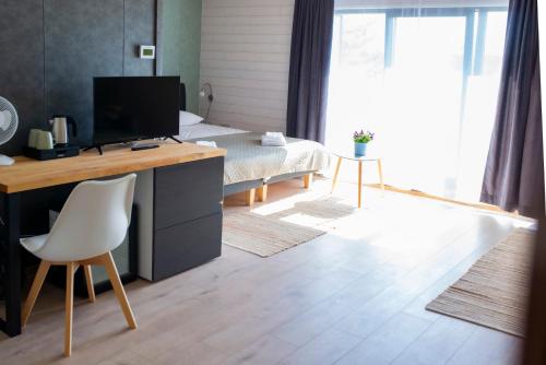 a bedroom with a desk with a computer and a bed at Hiiumaa Sõru Puhkemaja in Sõru