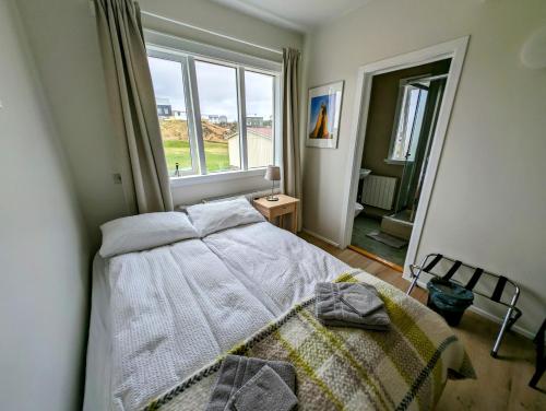 a bedroom with a bed and a large window at The Stykkishólmur Inn in Stykkishólmur