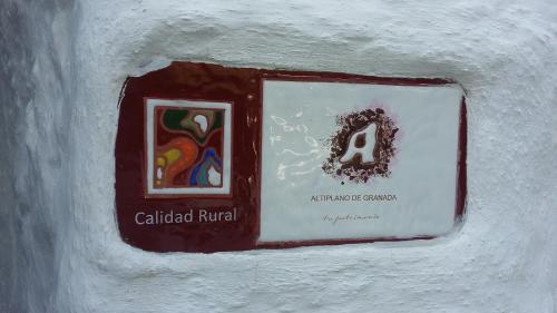 a sign on a wall with a picture on it at Al Jatib in Baza