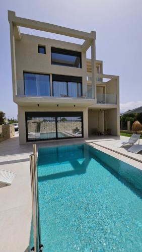 a house with a swimming pool in front of a house at Kooba Villas in Gázion