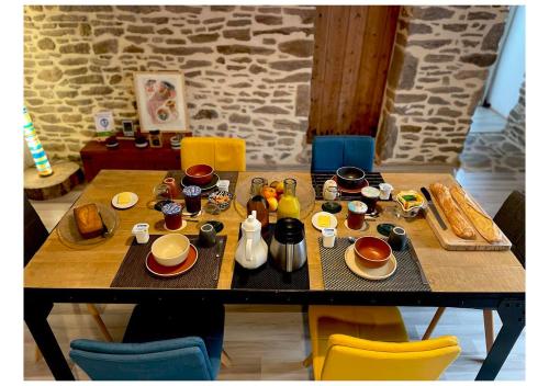 a table with breakfast foods and coffee on it at Le Bercail in Plouézec
