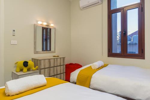 a bedroom with two beds and a mirror and a window at Bubble Beach 2-BR in Batroun Souks - Parking in Batroûn