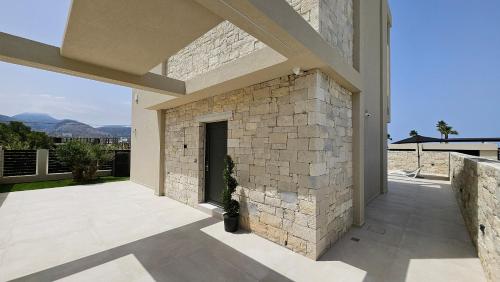 a patio with a stone wall and a building at Kooba Villas in Gázion
