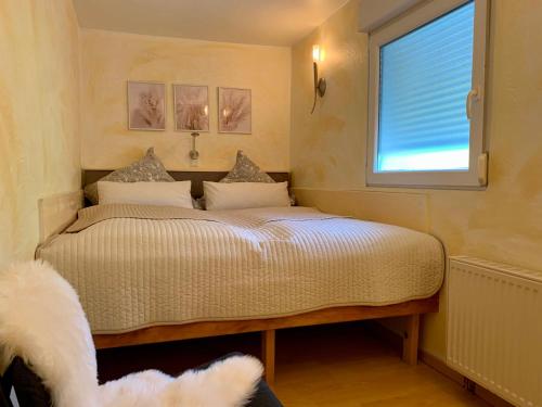 Dormitorio pequeño con cama y ventana en Idyllisches Ferienhaus in ruhiger Lage en Wölsickendorf-Wollenberg