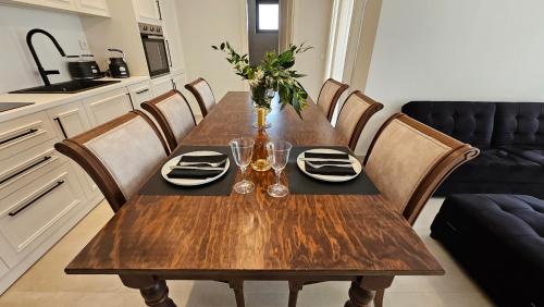 a wooden table in a kitchen with plates and wine glasses at Kooba Villas in Gázion