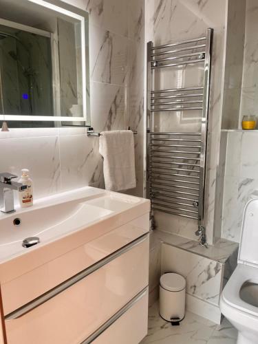 a bathroom with a sink and a tub and a toilet at Hyde Park,3 min walk,Family home! 2 Bedrooms & 2 Bathrooms Apartment! Fantastic Location in London