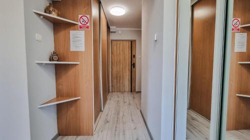 a hallway with wooden shelves and a door at Welcome in Ostróda