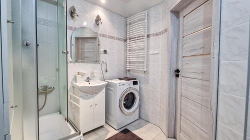 a bathroom with a washing machine and a washer at Welcome in Ostróda