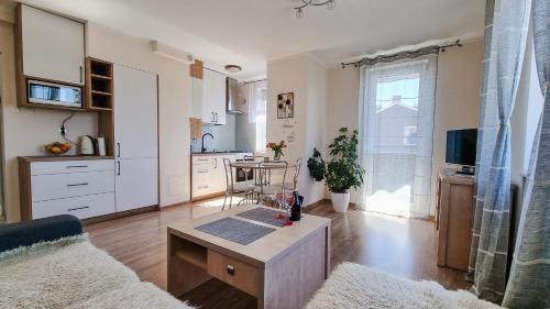 a living room with a table and a kitchen at Welcome in Ostróda