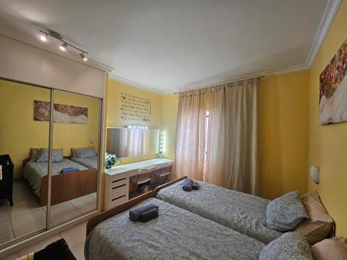 - une chambre avec 2 lits et un miroir dans l'établissement Away but Home, à San Miguel de Abona