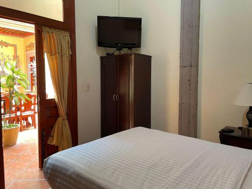 1 dormitorio con 1 cama y TV de pantalla plana en HOTEL CASONA MISIONES, en Querétaro
