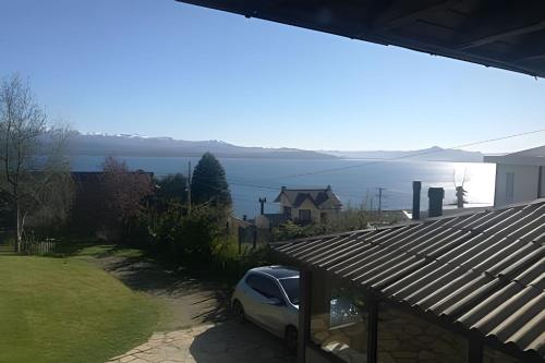 a car parked in a yard next to a house at Acogedora casa con vista al lago complejo turístico in San Carlos de Bariloche