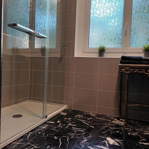 a shower with a glass door in a bathroom at Mont Joly Gîte in Soumont-Saint-Quentin