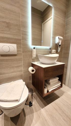 a bathroom with a sink and a toilet and a mirror at Old Town Villa in Durrës