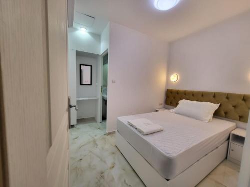a white bedroom with a bed and a bathroom at AHAMED GREEK SMPCO in Athens