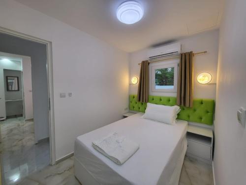a bedroom with a white bed and a window at AHAMED GREEK SMPCO in Athens