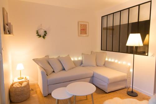 un salon avec un canapé blanc et une table dans l'établissement Appartement Terrasse Jardin à 2 pas de la plage, à Wissant