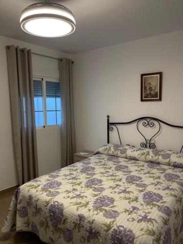 1 dormitorio con 1 cama con colcha de flores en Casa Carmen. Villa Romana Salar, en Salar