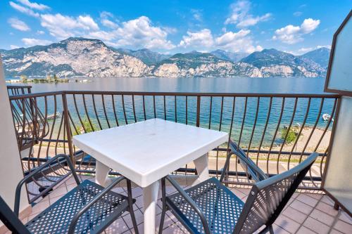a table and chairs on a balcony with a view of the water at Locanda Bellavista food&rooms in Malcesine