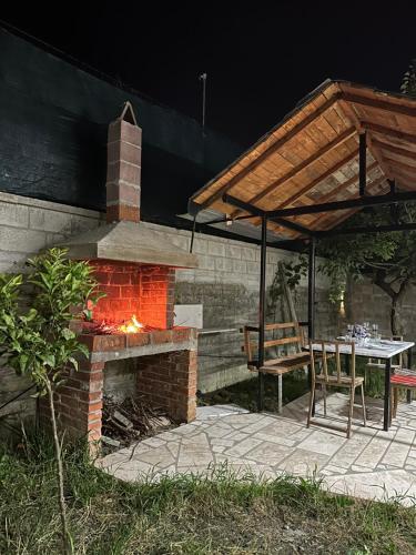 a patio with a brick fireplace and a table and chairs at Villa For Rent in Durrës