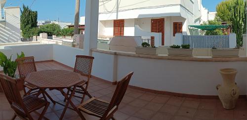 un patio con tavolo e sedie sul balcone. di b&b Stella marina torre guaceto a Specchiolla