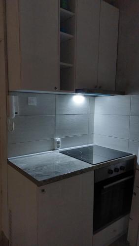 a kitchen with white cabinets and a counter top at Plavi Tirkiz in Pančevo