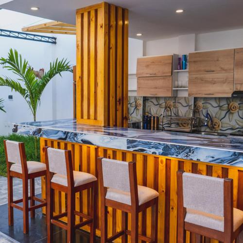 a kitchen with a wooden counter with four chairs at ANTONELLA'S House in Huanchaco