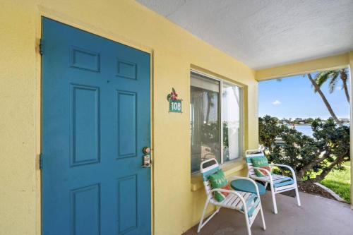 a porch with two chairs and a blue door at Malyn 108, Updated Waterfront condo, private patio in St Pete Beach