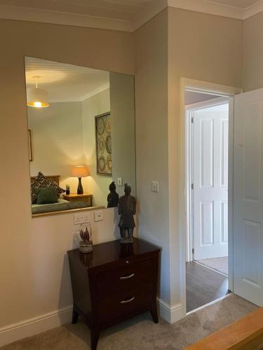 a room with a mirror and a dresser with a lamp at Riverbank Lodge in Dollar