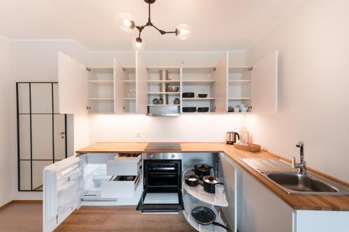 a kitchen with white cabinets and a sink at Promenaden Lounge in Merano