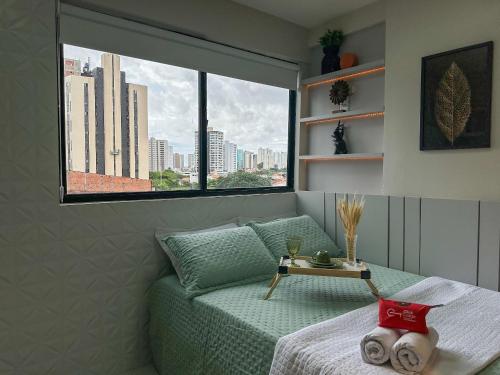 a living room with a green couch and a window at (106) Studio charm - Perto da praia in São Luís