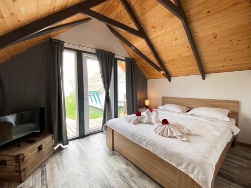 a bedroom with a large bed and a television at Complex Turistic Răsărit Corbu in Corbu
