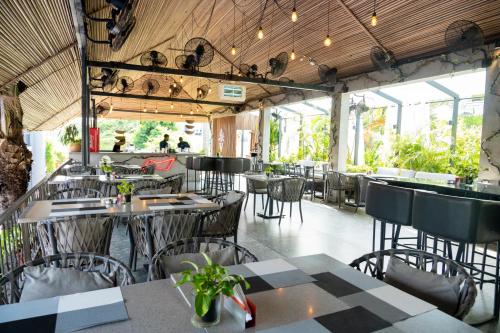 a restaurant with tables and chairs and windows at Vertigo Hotel in Lagos