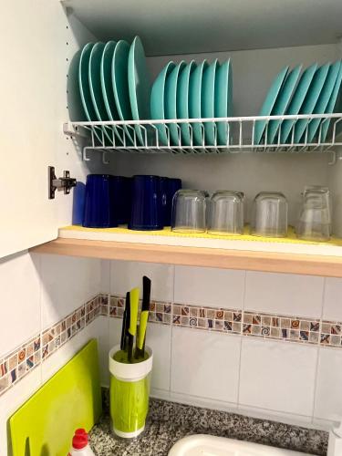 a kitchen with green plates on a shelf at Apartament Sony in Denia