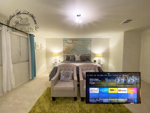a bedroom with a bed with two chairs and a tv at Bella's sweet house 11155 in Mira Loma