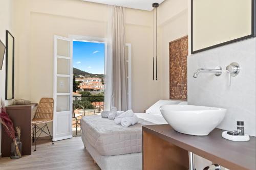 uma casa de banho com um lavatório e uma cama com uma janela em Ethereal Stay em Spetses
