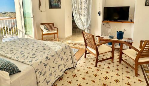uma sala de estar com uma cama, uma mesa e cadeiras em Ponza Le Forna em Ponza