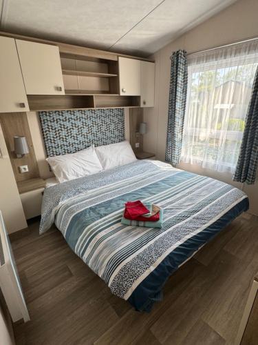 ディナールにあるMobil-home tout confortのベッドルーム1室(大型ベッド1台、赤い袋付)