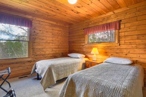 2 camas en una cabaña de madera con 2 ventanas en Charming Lovell Cabin - 7 Mi to Kezar Lake!, en Lovell