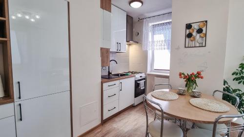 a kitchen with a table and chairs and a kitchen with white cabinets at Welcome in Ostróda