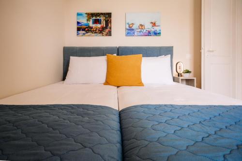 uma cama com um edredão azul e branco e uma almofada laranja em Country House in Agios Leon em Agios Leon