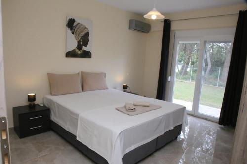 a bedroom with a large white bed with two candles on it at Haris Studio 1 in Keramoti