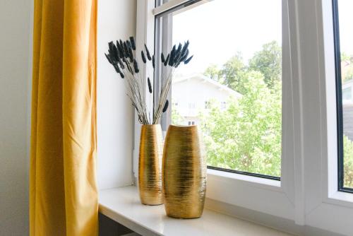two vases are sitting on a window sill at UNiQE I Stilvolle 115qm I Terrasse I BBQ in Feldafing