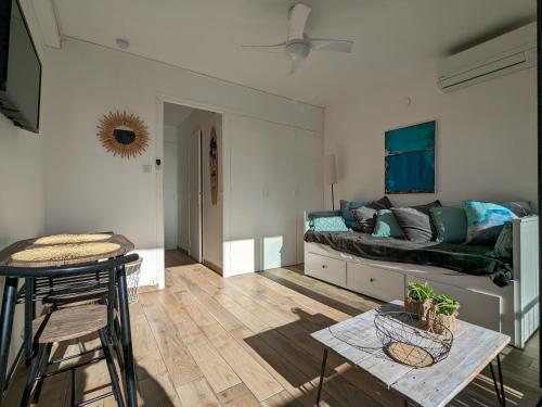 un salon avec un canapé et une table dans l'établissement Charmant studio calme et climatisé, près de la plage, à Canet en Roussillon, à Canet