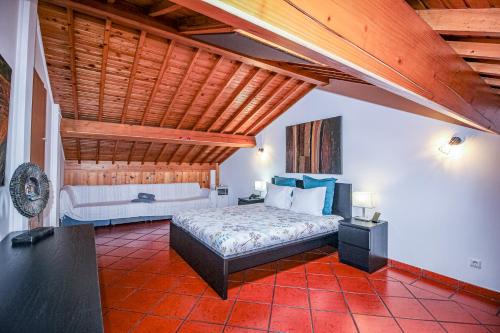 1 dormitorio con cama y techo de madera en Casa Vereda, Ponta Delgada, S. Miguel en Ponta Delgada