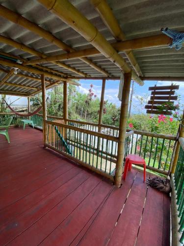 a wooden deck with a red bench and a fence at Finca la Divisa. Senderos de la Montaña in San Vicente