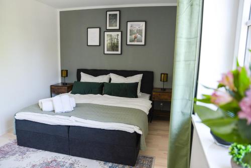 a bedroom with a bed with green and white pillows at UNiQE I Stilvolle 115qm I Terrasse I BBQ in Feldafing