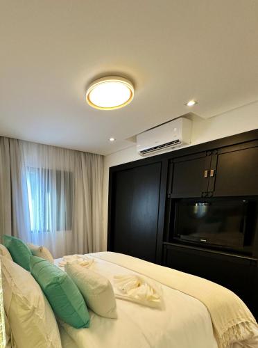 a bedroom with a bed with a television on the wall at São Paulo Nações Unidas - Luxury Suíte in São Paulo