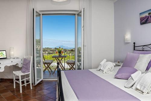 1 dormitorio con cama, escritorio y balcón en Casa La Cycas, en Massa Lubrense