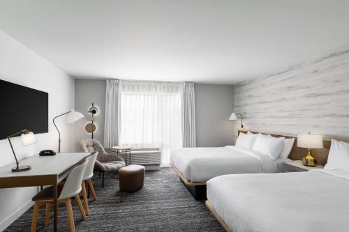 a hotel room with two beds and a desk at TownePlace Suites by Marriott Iron Mountain in Iron Mountain